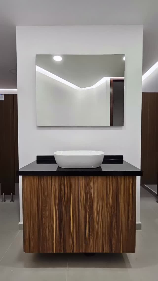 Mueble de baño flotante con cubierta negra y acabado nogal, instalado por Lia Cucina