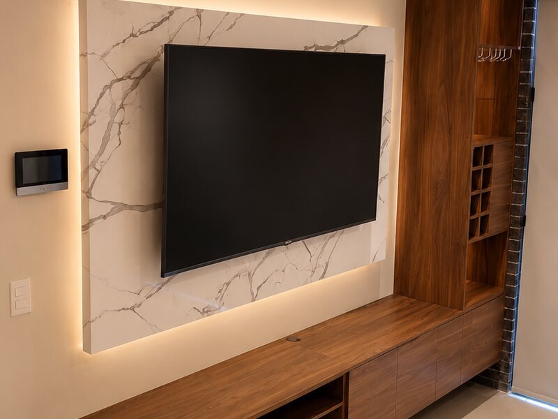 Detalle de muro de mármol con iluminación integrada y mueble de nogal